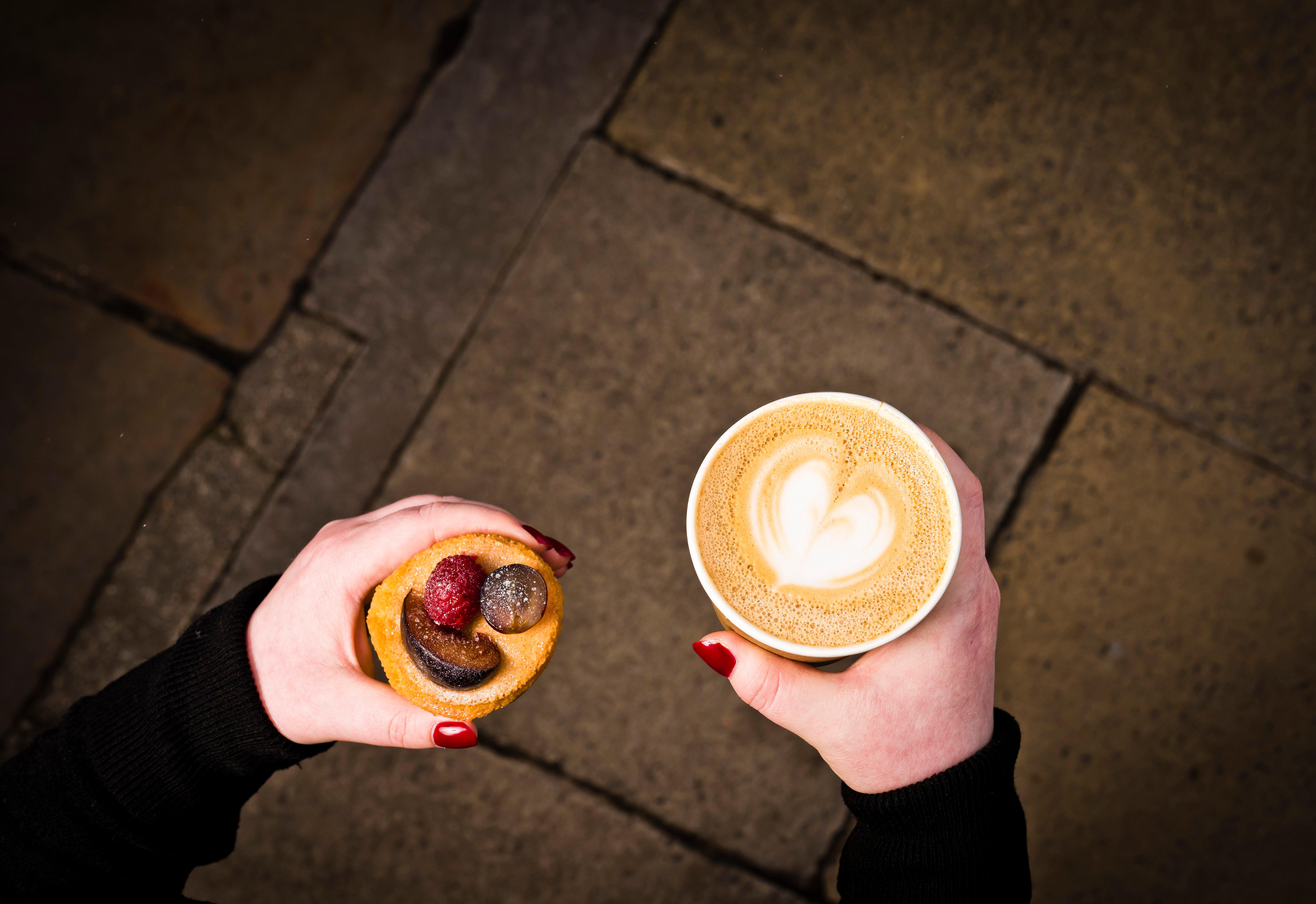 인터컨티넨탈 에든버러 더 조지 외부 사진 A woman holding a coffee and a doughnut